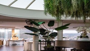 A spacious indoor area with a high ceiling, large windows, and a view of a cityscape. - Hotel Il Gabbiano (Bacoli)