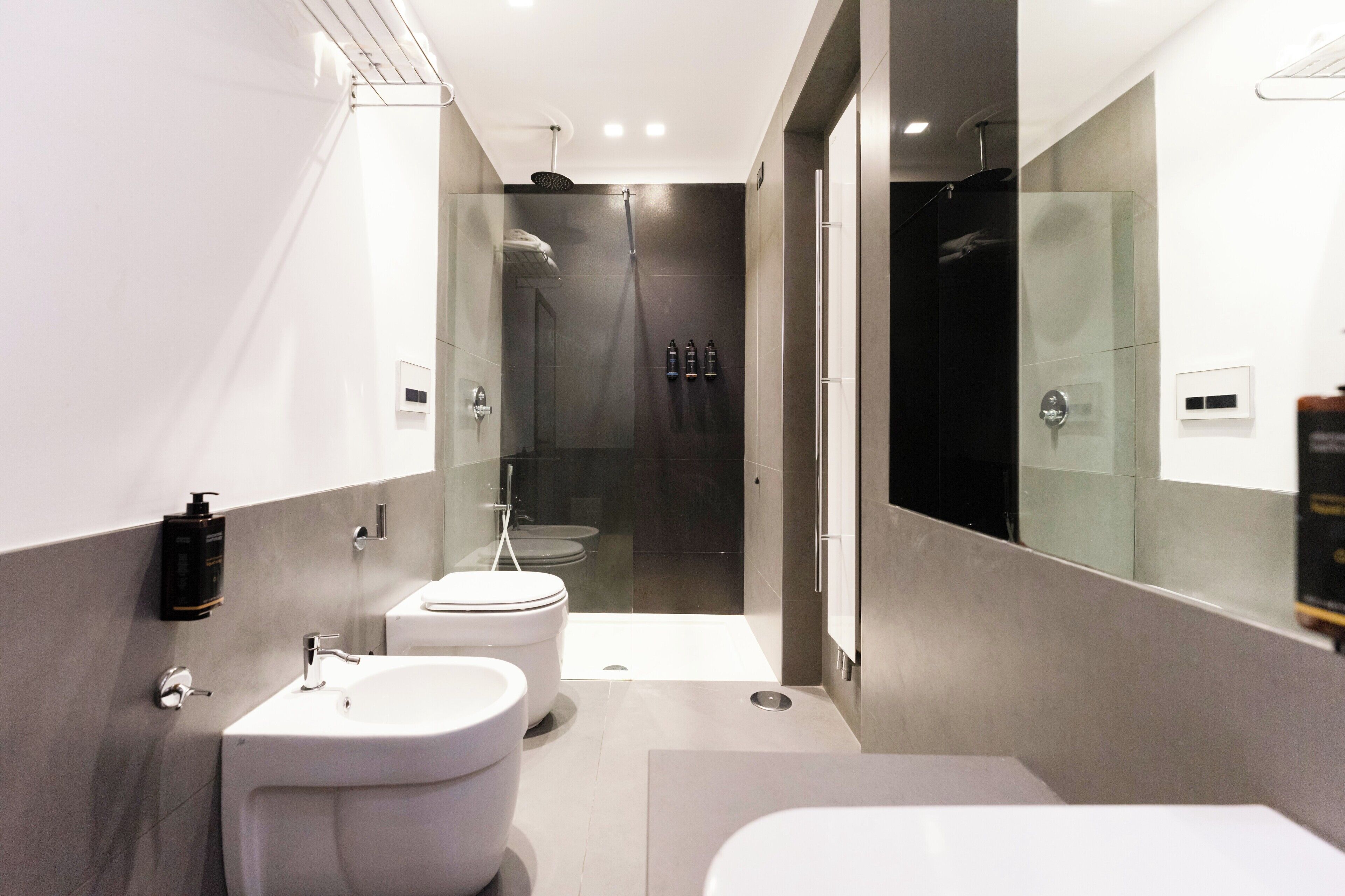 A modern bathroom with a shower, toilet, and sink.
