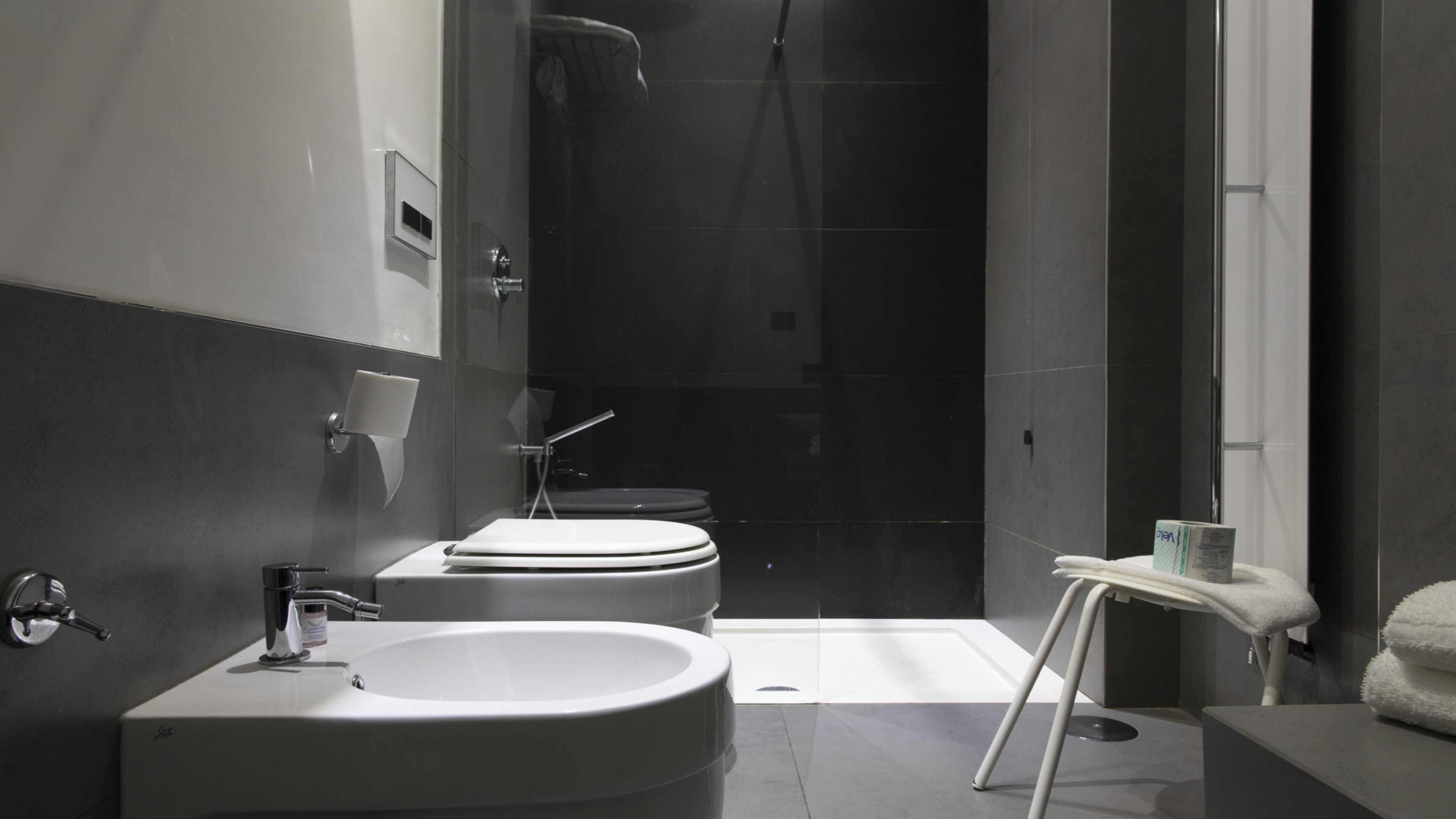 A modern bathroom with a large sink, toilet, and shower.
