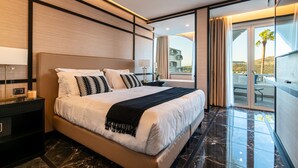 A modern hotel room with a large bed, a nightstand, a lamp, and a view of the outdoors. - Hotel Il Gabbiano (Bacoli)