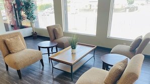 A modern living room with a sofa set, coffee table, and a potted plant. - Days Inn by Wyndham San Diego-East/El Cajon (El Cajon)