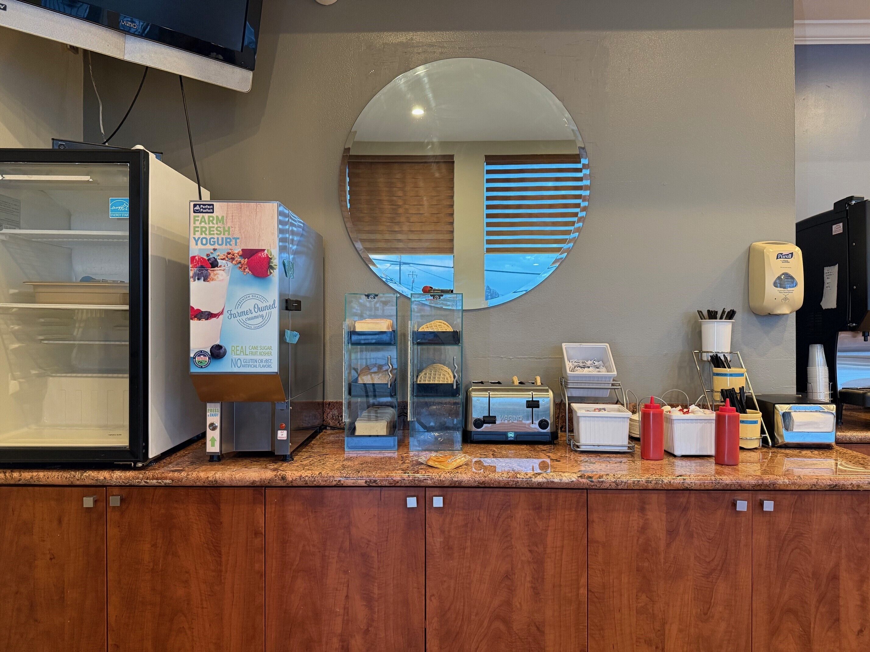 Een toonbank met een gekoeld display, een spiegel, een koffieapparaat en diverse bakken.