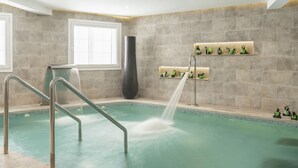 A spa pool with a water feature, metal railings, and decorative shelves with figurines. - Hotel Vincci Selección Rumaykiyya (Monachil)