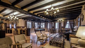A spacious room with high ceilings, exposed beams, and a variety of seating options including sofas and chairs. - Hotel Vincci Selección Rumaykiyya (Monachil)