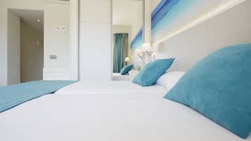 Une chambre d’hôtel avec un grand lit, deux oreillers, une table de chevet avec une lampe et un tableau au mur.