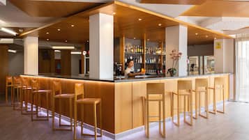 Eine moderne Bar mit Holzhockern und einem Barkeeper.