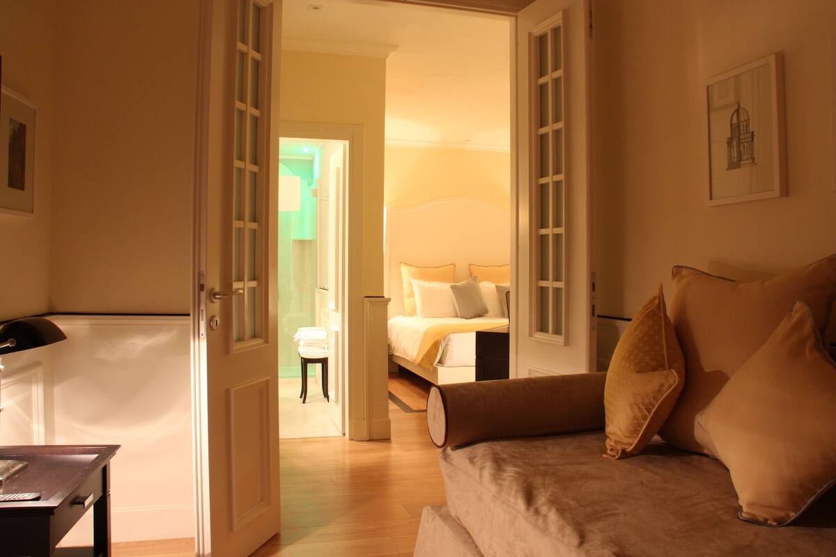A hotel room with a bed, a sofa, and a desk.