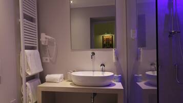 Une salle de bain moderne avec un grand lavabo, un miroir et une douche en verre.