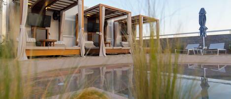 A poolside area with outdoor seating and a television.