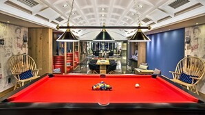 A pool table with balls, a dining area with chairs, and a ceiling with recessed lighting. - Airotel Alexandros Hotel (Athens)