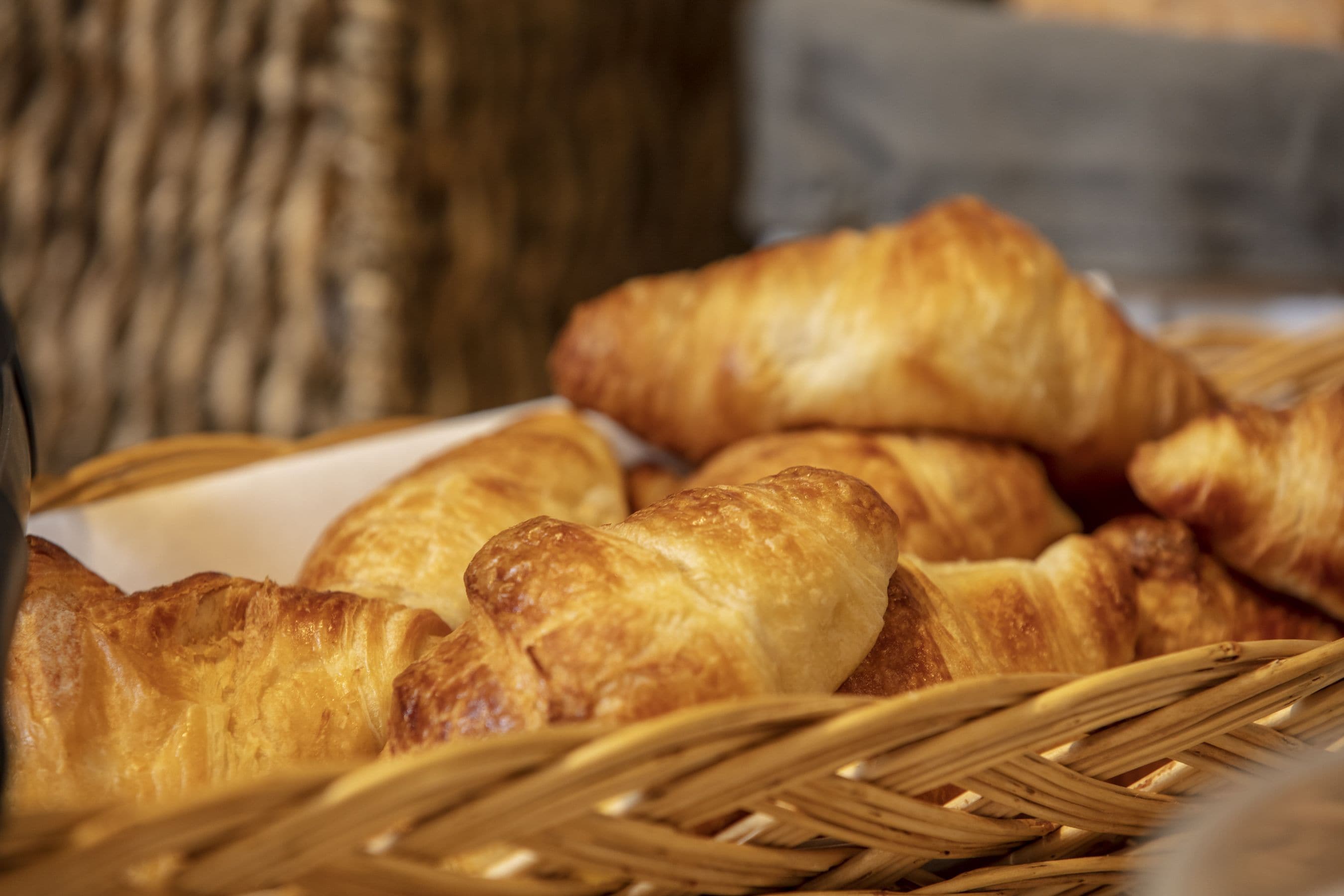 A basket of golden-brown croissants.