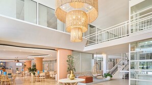 A spacious lobby with a high ceiling, a central round table, and a hanging chandelier. - Laguna Maradiso Hotel by Aminess  (Novigrad)