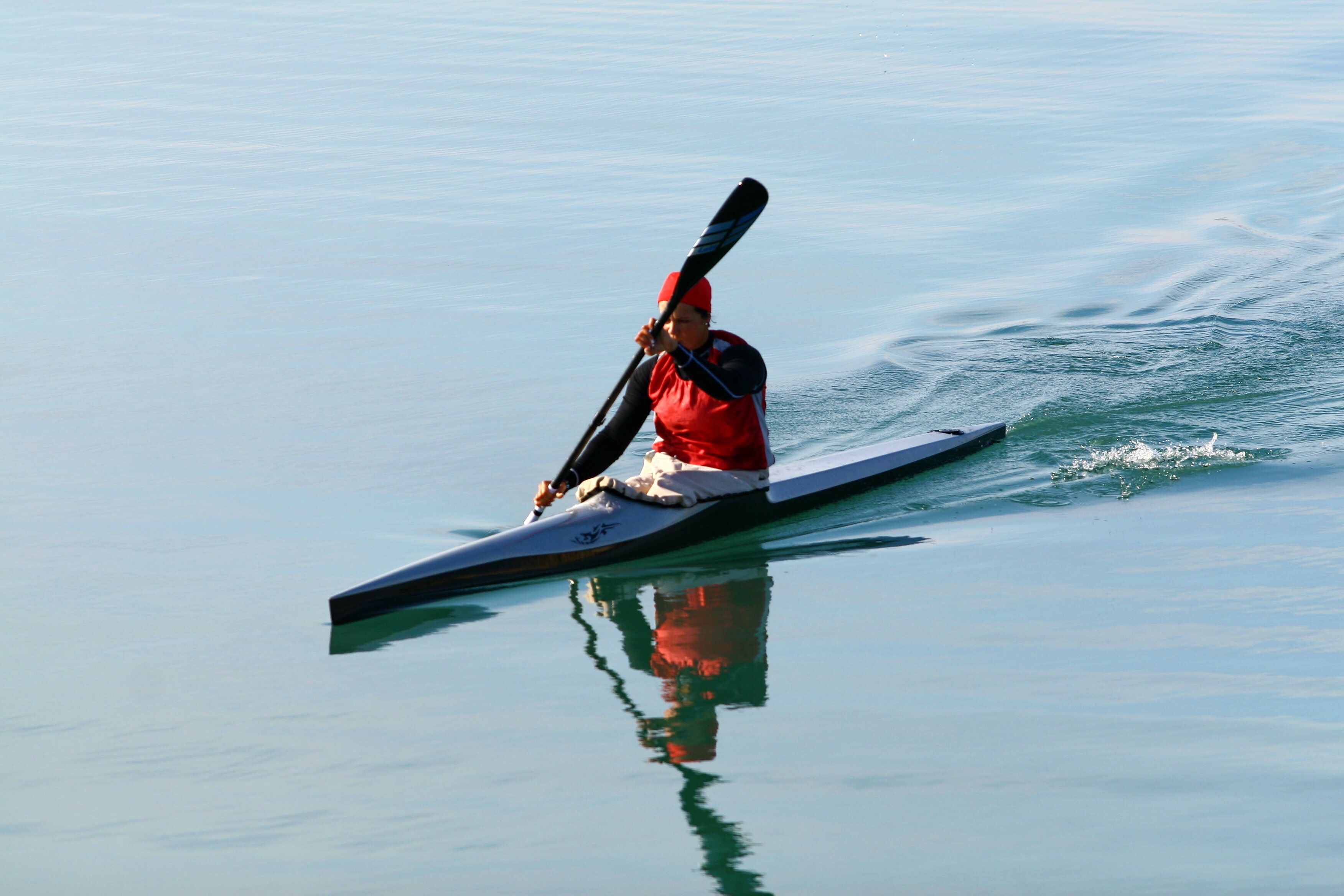 A person kayaking on calm water.
