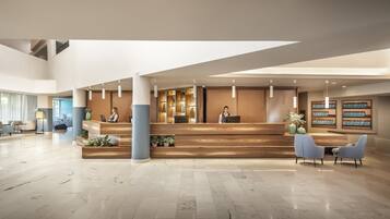 Eine geräumige Lobby mit einer Rezeption, Sitzgelegenheiten und großen Fenstern.
