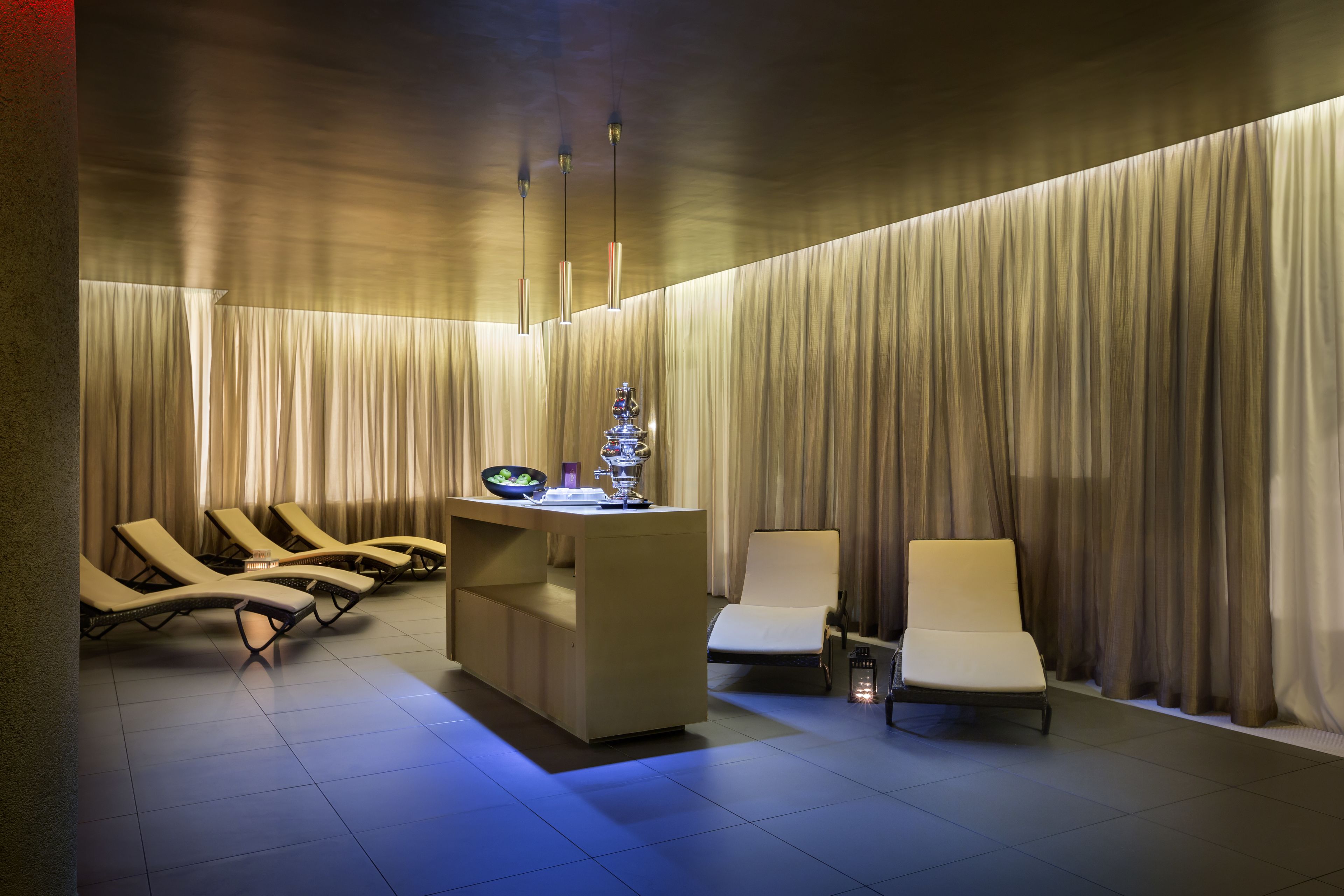 A spa area with a reception desk, lounge chairs, and a massage chair.