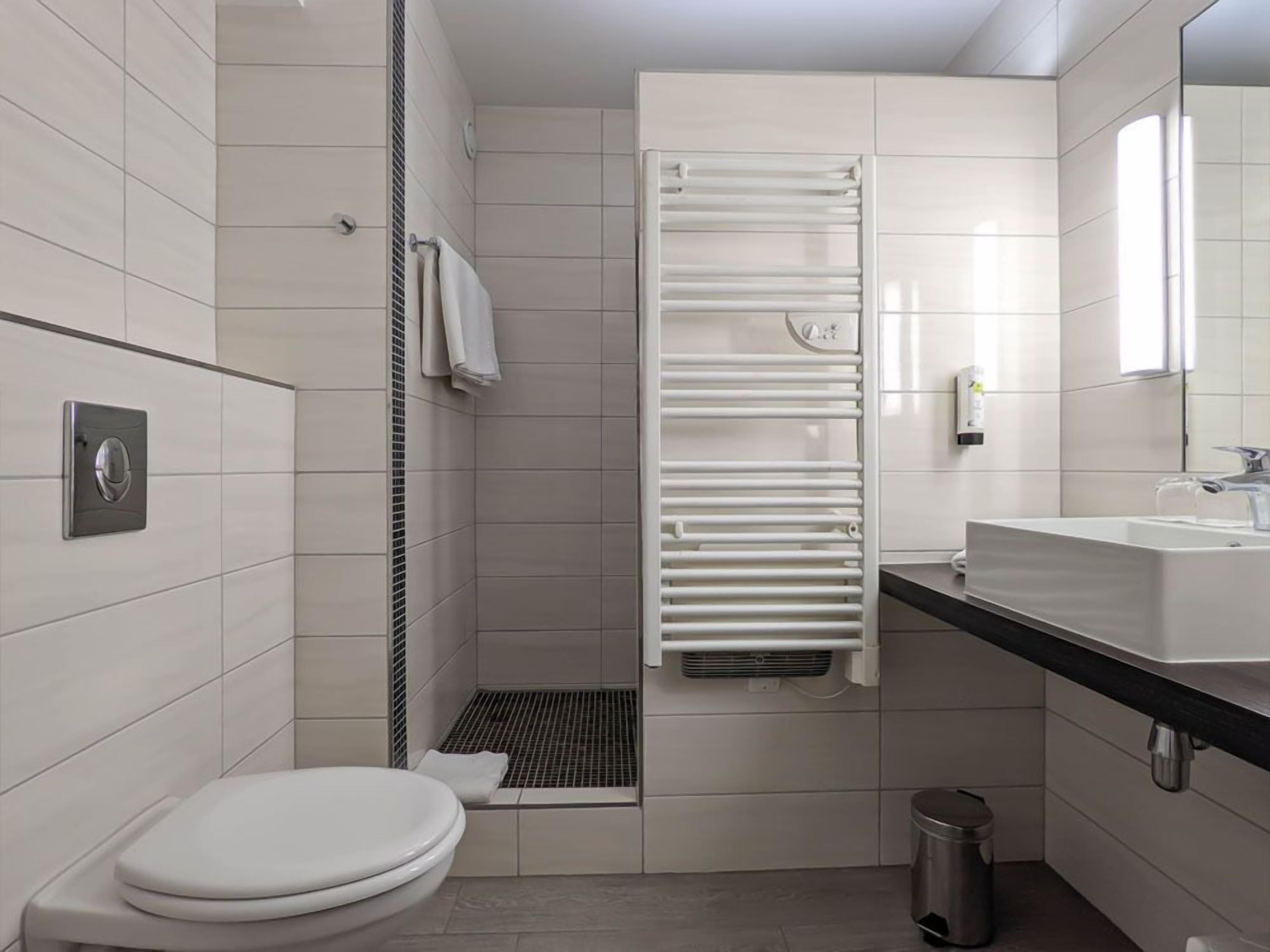 Ein modernes Badezimmer mit Toilette, Waschbecken und Dusche.