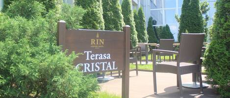 A sign for the RIN Airport Hotel Terasa Cristal with outdoor seating.