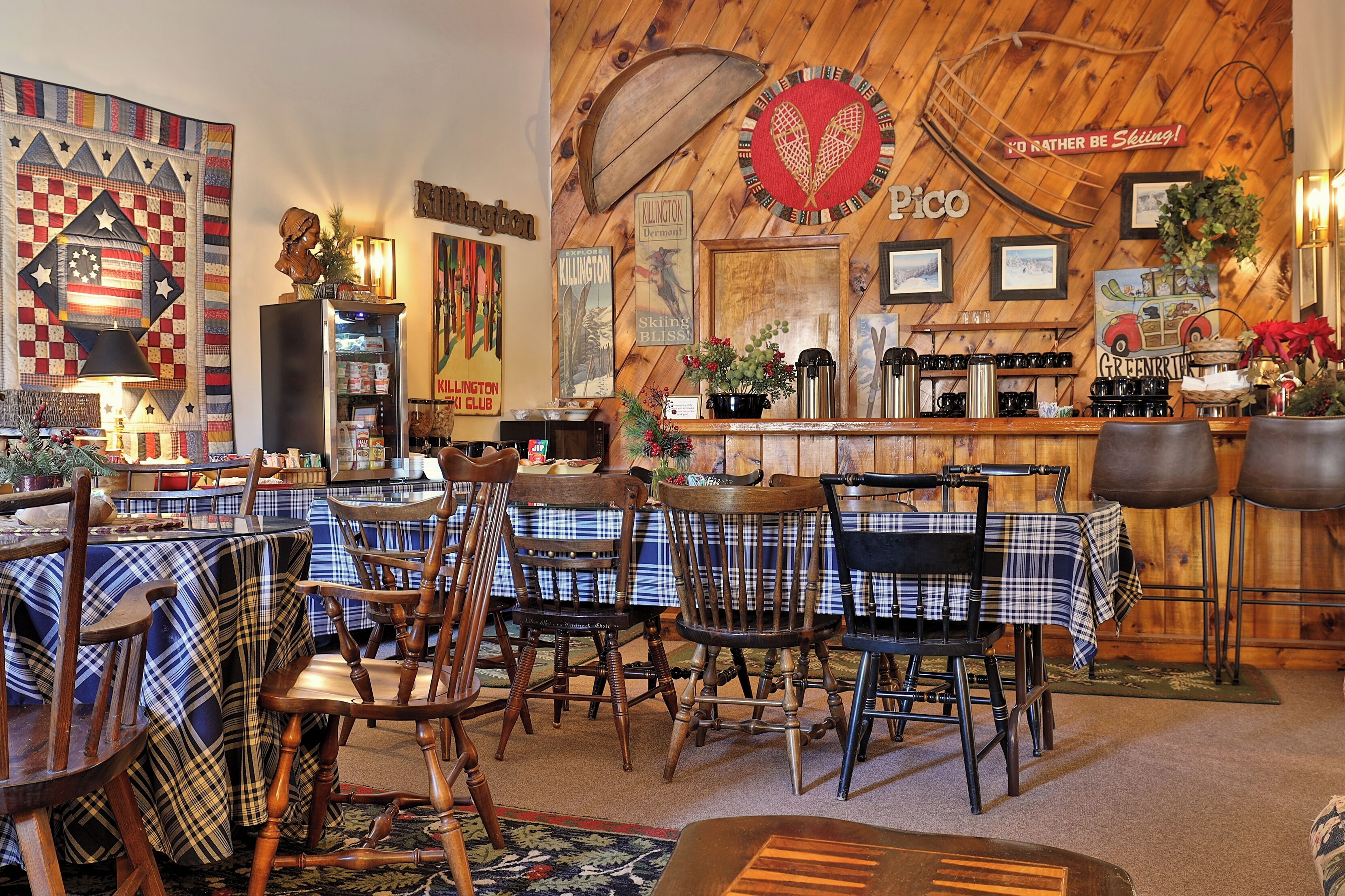 A cozy restaurant with wooden walls, plaid tablecloths, and vintage decor.