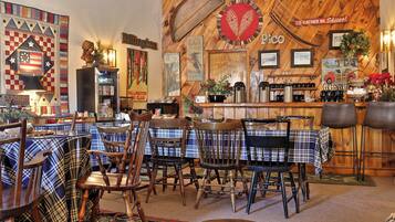 A cozy restaurant with wooden walls, plaid tablecloths, and vintage decor.