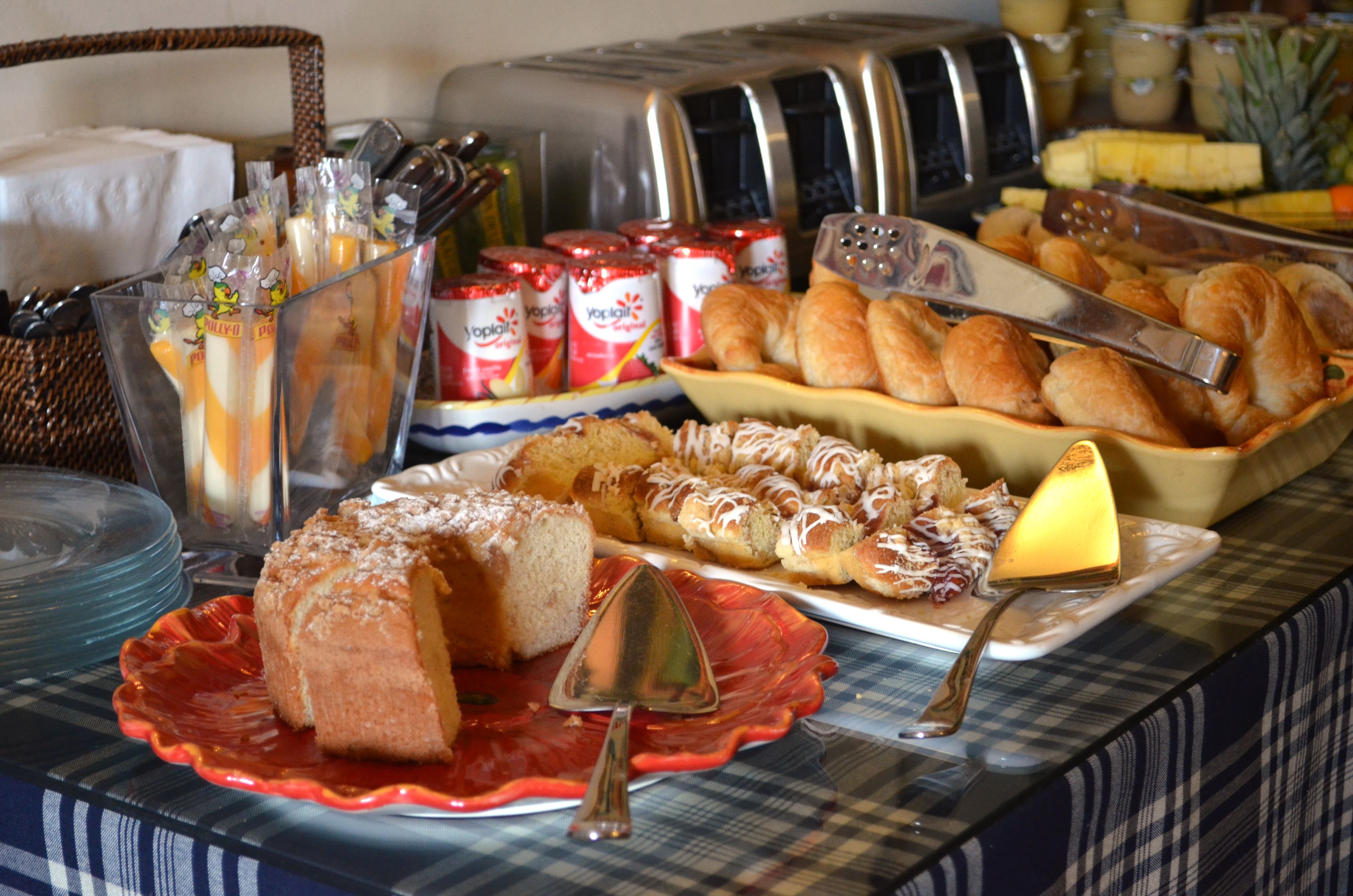Una mesa de buffet con diversos alimentos, como pasteles, pan y salsas.