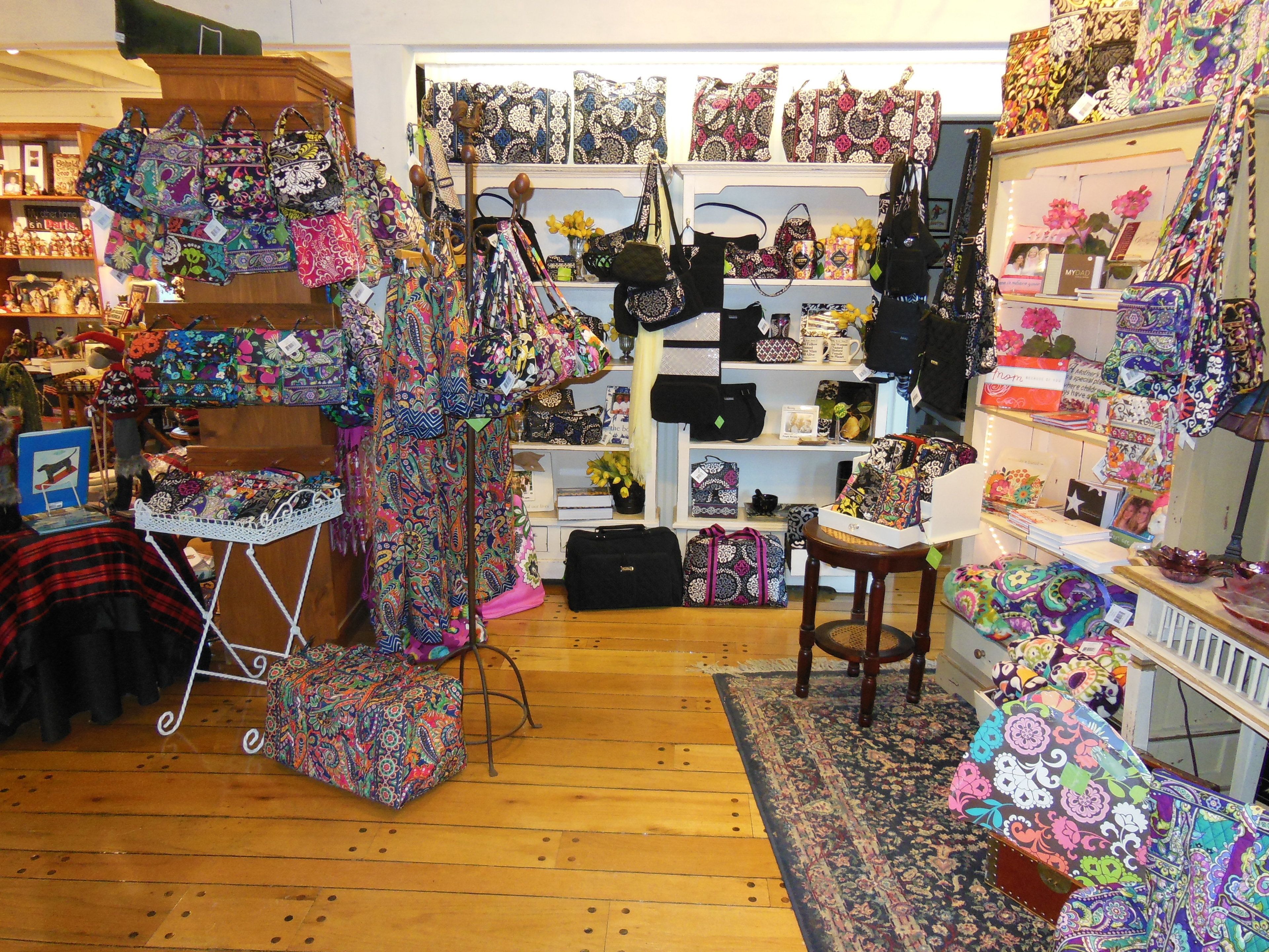 A boutique store with a variety of colorful bags and accessories displayed on shelves and tables.