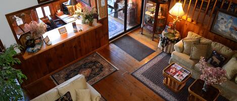 Uma sala de estar acolhedora, com piso de madeira, um sofá, uma mesa de centro e um espaço de refeições com mesa e cadeiras.