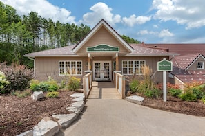 A guest check-in building with a ramp leading to the entrance, surrounded by landscaped gardens and a clear sky. - Carriage Ridge Resort, an Ascend Collection Resort (Oro-Medonte)