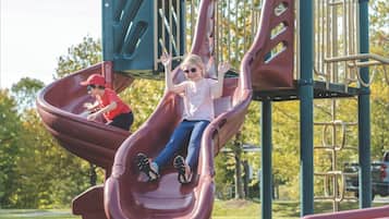 Un parc infantil amb tobogan i elements per escalar.