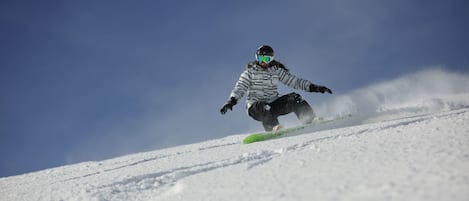 A snowboarder in motion on a snowy slope.