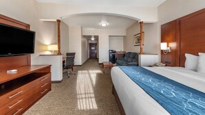 A hotel room with a large bed, a TV, a desk, and a kitchenette. - Citrus Suites Redlands Loma Linda Hotel (Redlands)