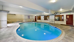 An indoor swimming pool with clear blue water, tiled floor, and a pool ladder. - Citrus Suites Redlands Loma Linda Hotel (Redlands)