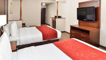 Ein Hotelzimmer mit zwei Betten, einem Fernseher, einem Schreibtisch und einem Stuhl.