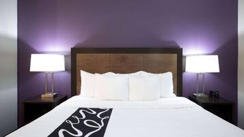 A hotel room with a large bed, two bedside tables, and a headboard.