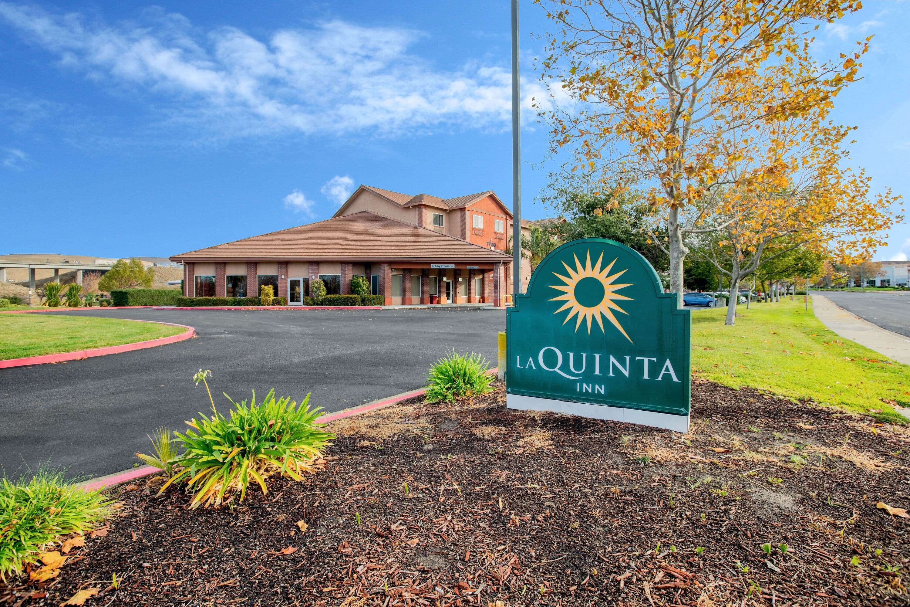 A La Quinta Inn sign with a clear view of the building in the background.