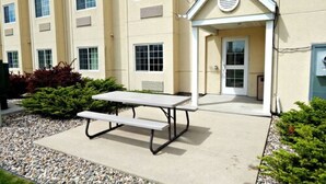 An outdoor patio area with a picnic table and a small covered seating area. - Microtel Inn & Suites by Wyndham Mankato (Mankato)