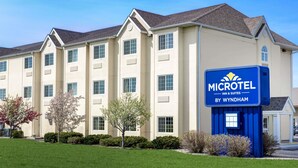 A Microtel Inn & Suites building with a beige exterior, multiple windows, and a blue sign. - Microtel Inn & Suites by Wyndham Mankato (Mankato)