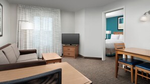 A hotel room with a sofa, a TV, a desk, and a dining table. - Residence Inn by Marriott Chico (Chico)