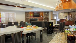 A restaurant with a stone wall, a flat-screen TV, and a bar area. - Residence Inn by Marriott Chico (Chico)