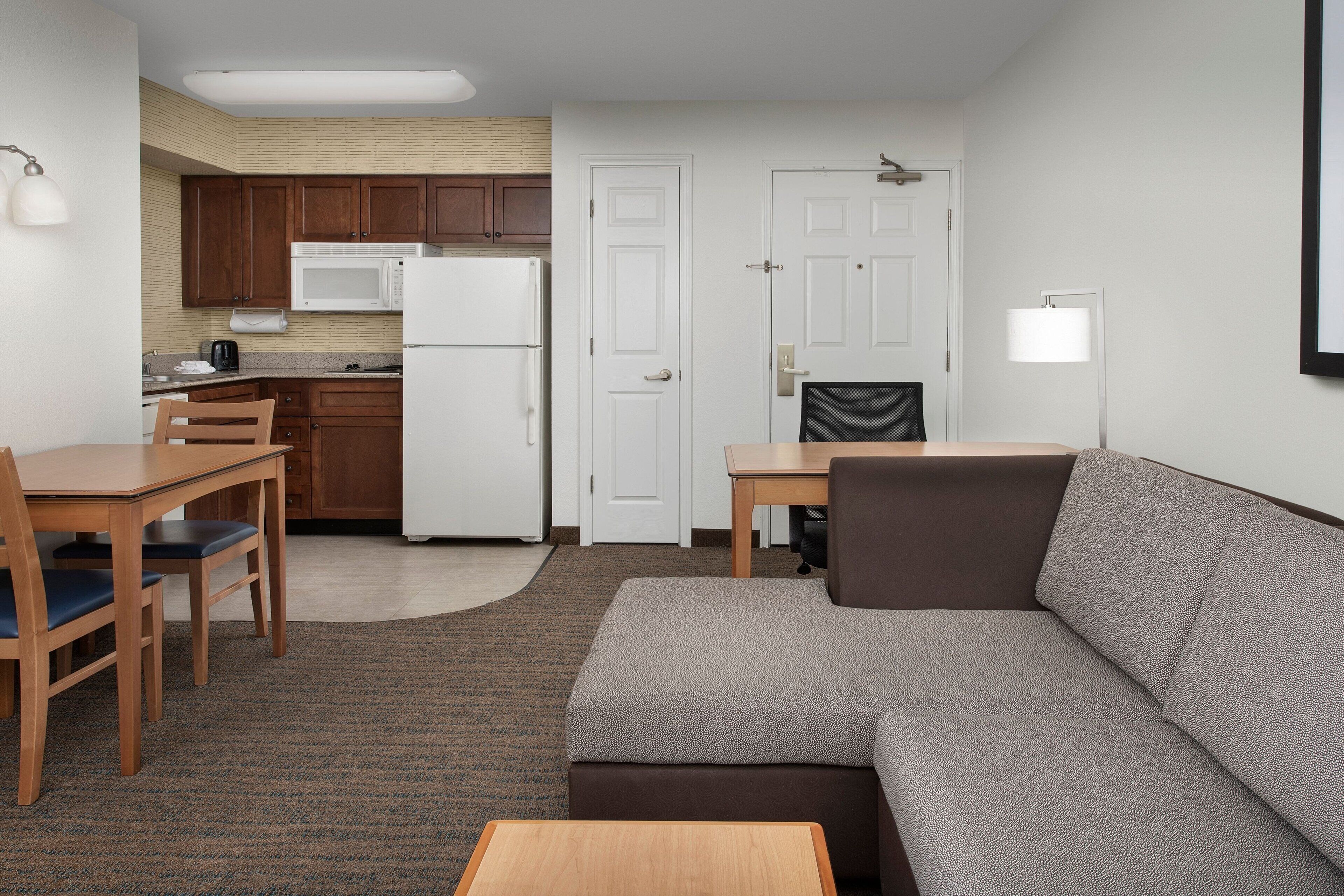 Un espacio habitable compacto con kitchenette, comedor y zona de estar.