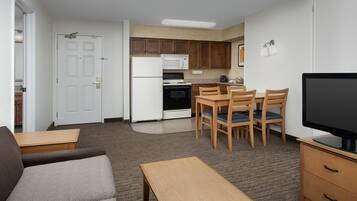 A compact living space with a kitchenette, a dining area, and a seating area.