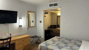 A hotel room with two beds, a desk, a chair, a television, a microwave, and a mirror. - Motel 6 Riviera Beach, FL (West Palm Beach)