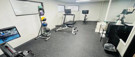 A gym with treadmills, exercise balls, and a stationary bike.