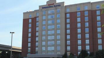 En høj hotelsbygning med skilt, der viser "Marriott Springhill Suites".