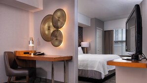 A hotel room with a desk, chair, bed, TV, and decorative wall lights. - Springhill Suites by Marriott Pittsburgh North Shore (Pittsburgh)