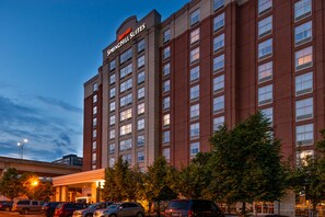 A Marriott Springhill Suites hotel with a brick facade, multiple windows, and a parking lot with several cars. - Springhill Suites by Marriott Pittsburgh North Shore (Pittsburgh)