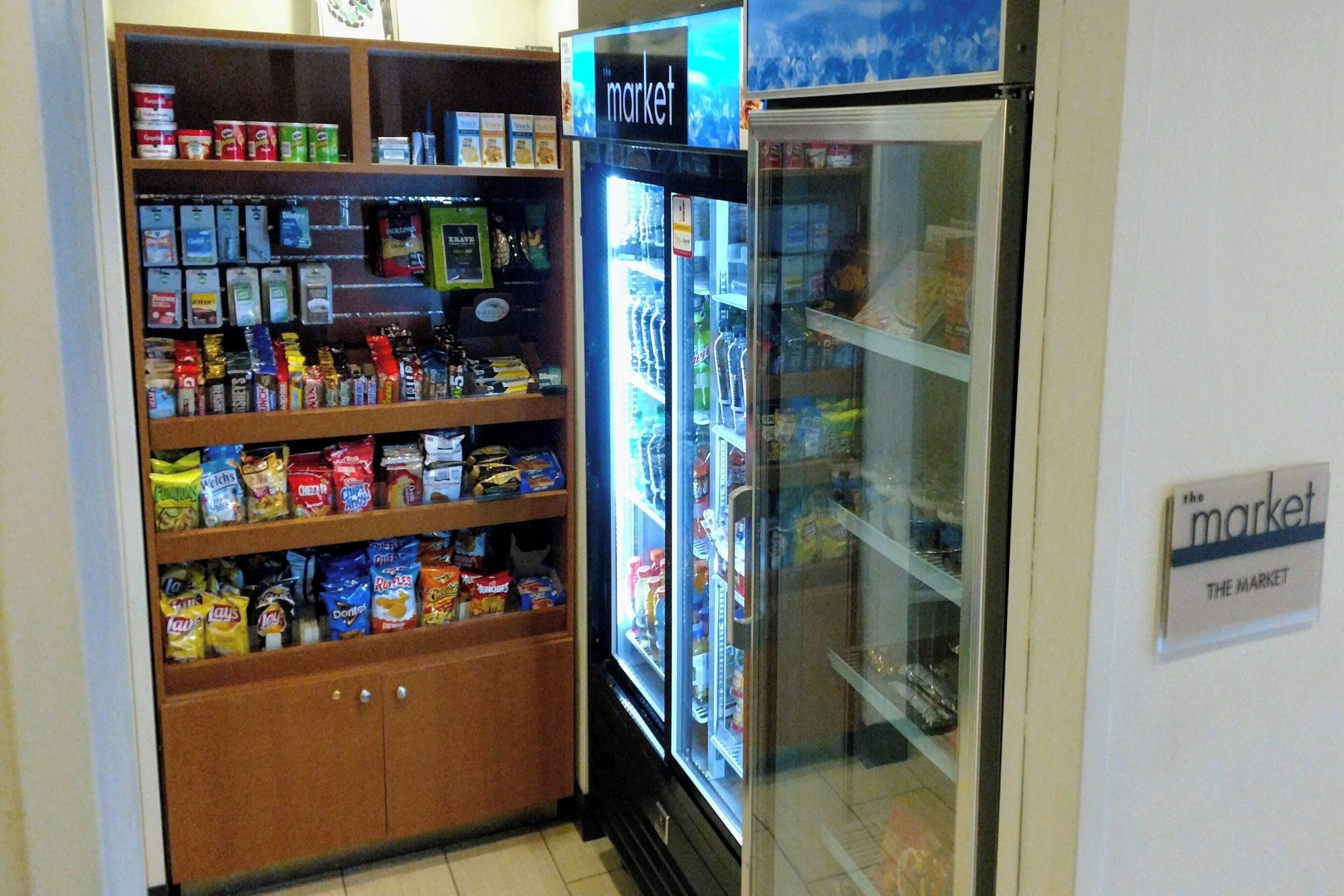 A snack and beverage refrigerator in a hotel room, with a variety of snacks and drinks visible.