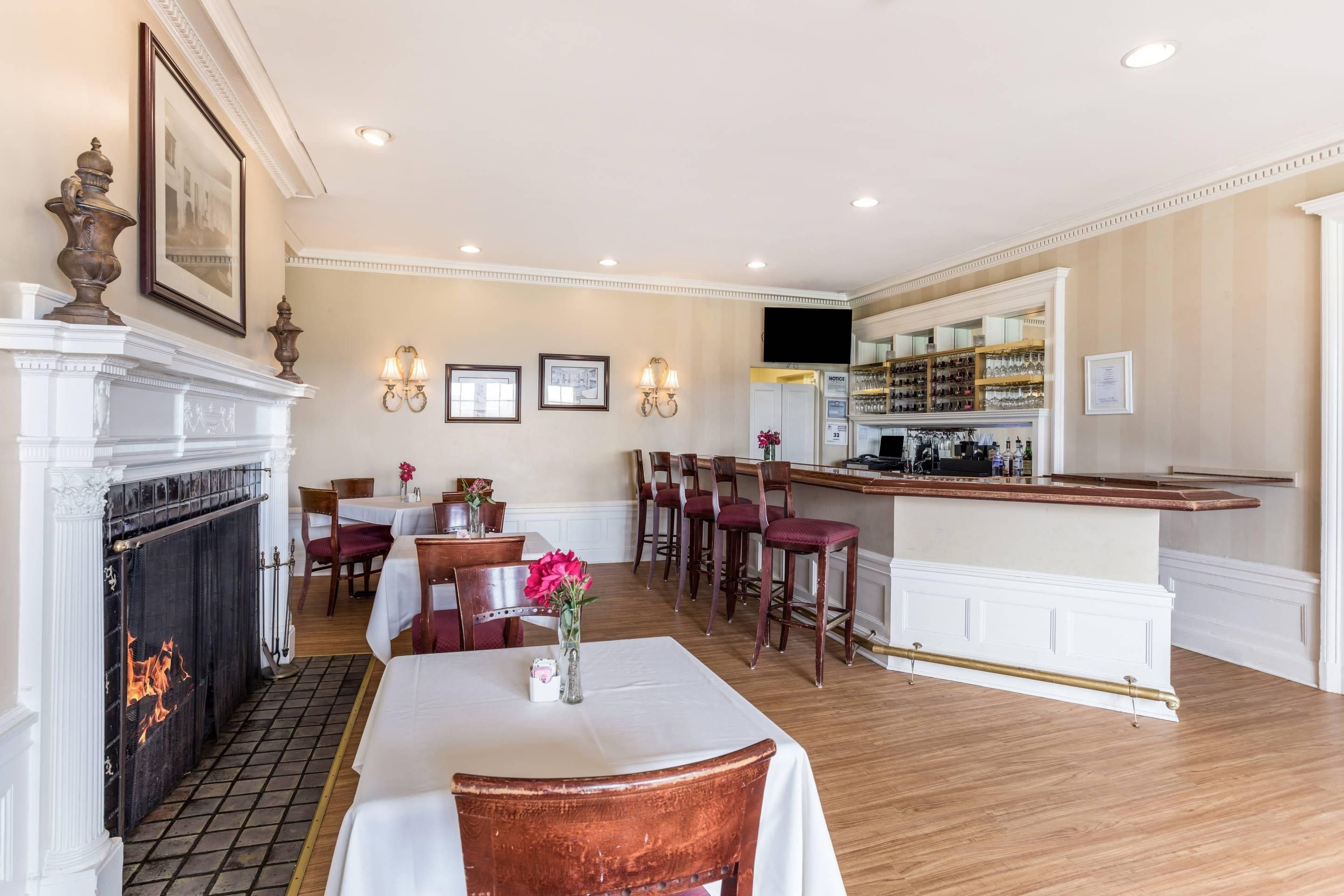 A dining area with a fireplace, a bar, and a seating arrangement.