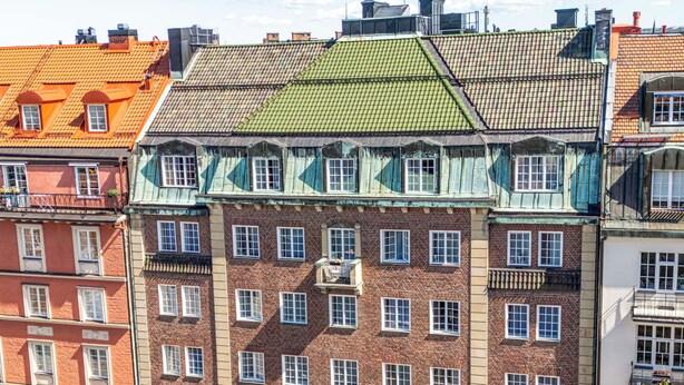 Un edificio de varios pisos con una entrada destacada, ventanas amplias y un letrero que dice 'HOTEL KARLAPLAN'.