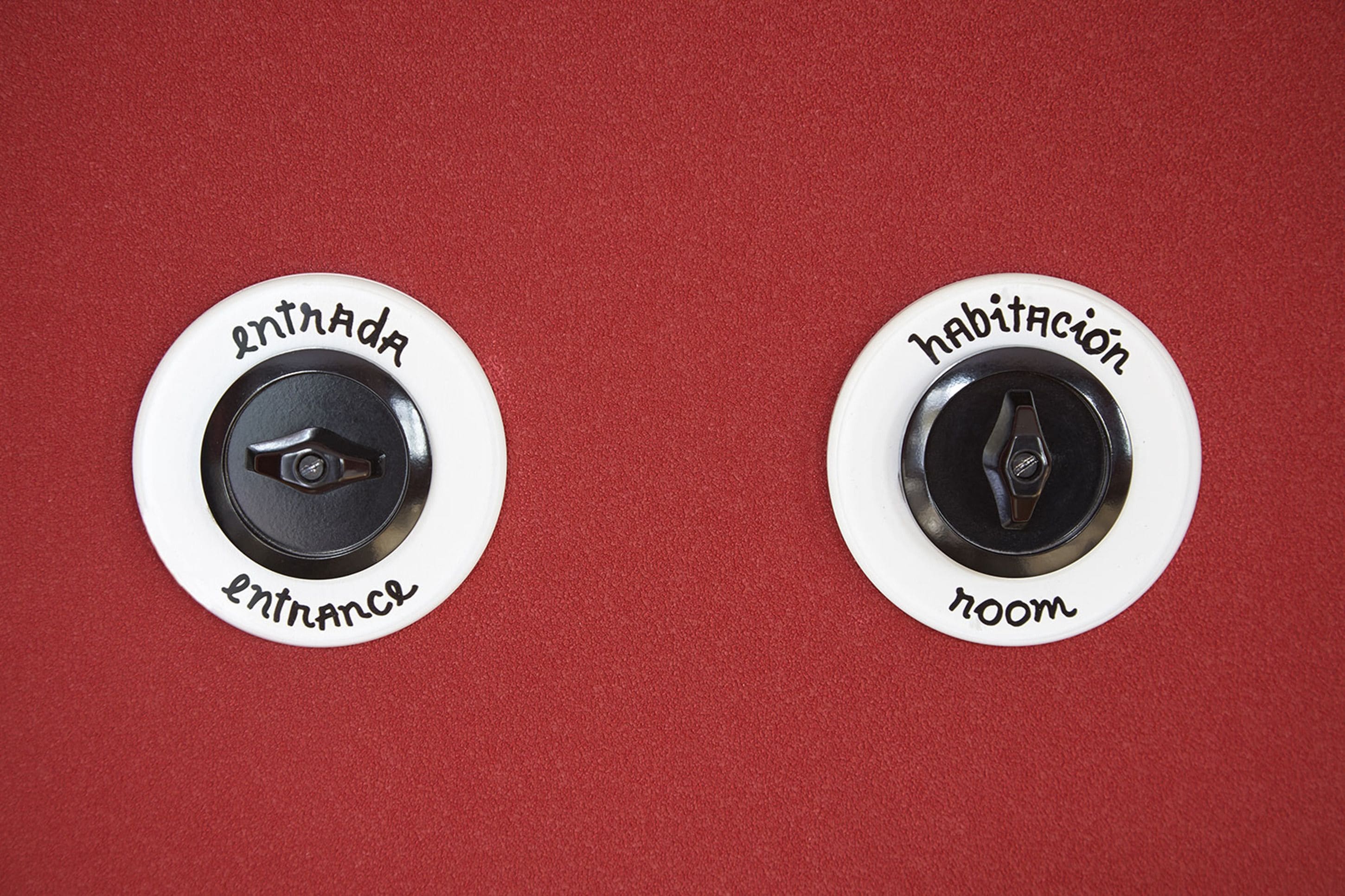 Two circular buttons labeled "entrada" and "habitación" on a red background.