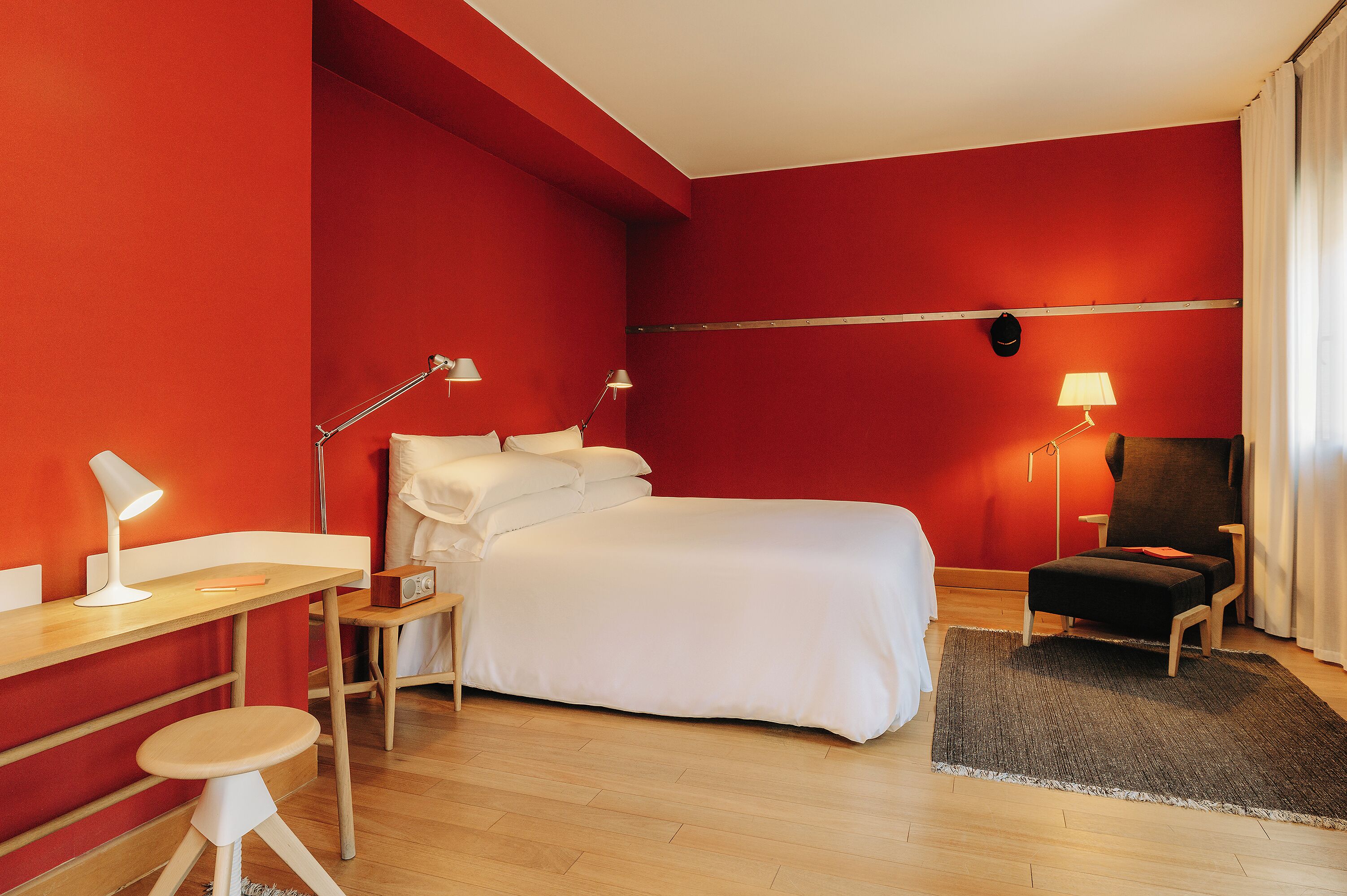 Ein Zimmer mit Bett, Schreibtisch, Stuhl und zwei Lampen.
